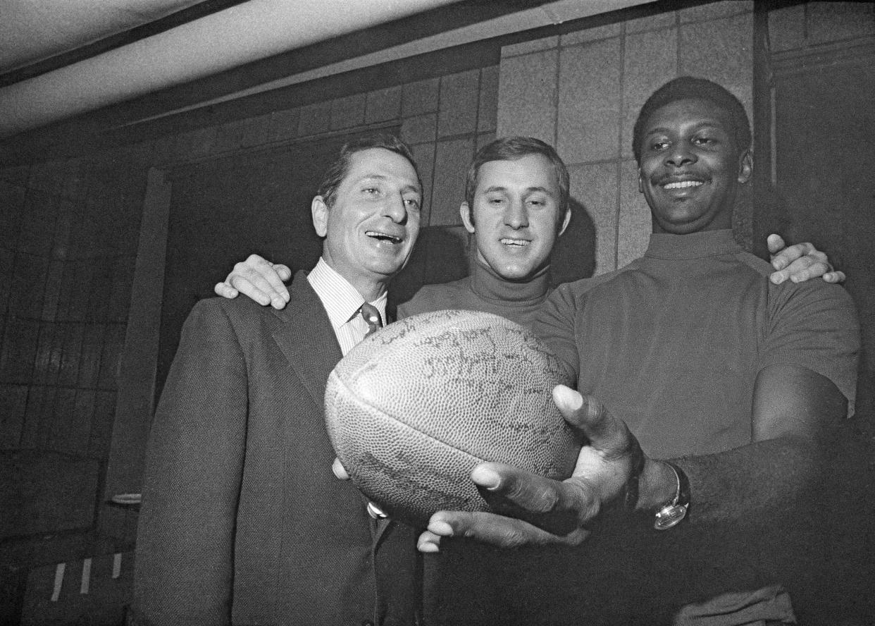 Allie Sherman, left, coach of the New York Giants, quarterback Fran Tarkenton, center, and flankerback Homer Jones, beam at an autographed pigskin at Yankee Stadium in New York, Nov. 12, 1968. The trio were still jubilant over the Giants' victory over the Dallas Cowboys on Nov. 10. (AP Photo/Harry Harris)