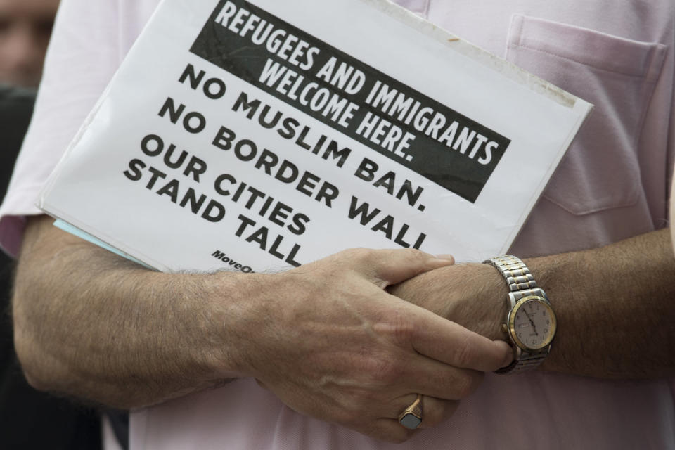 <span class="icon icon--xs icon__camera">  </span> <span class="credit font--s-m upper black"> <b>Jose Moreno</b> </span> <div class="caption space-half--right font--s-m gray--med db"> Rabbi, David Teutsch holds a sign to his chest, during an immigration protest outside of the United States Custom House </div>