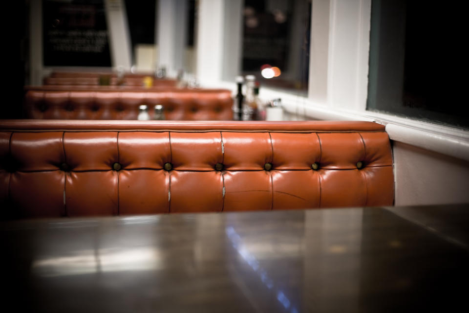 Empty diner booth with glossy floor, focus on textured seat cushion