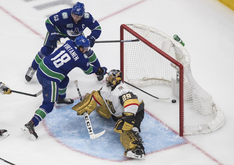 Vegas Golden Knights goalie Marc-Andre Fleury (29) is scored on by Vancouver Canucks' Bo Horvat (53) as Jake Virtanen (18) makes sure the puck stays in the net during the second period of an NHL Western Conference Stanley Cup playoff game, Sunday, Aug. 30, 2020, in Edmonton, Alberta. (Jason Franson/The Canadian Press via AP)