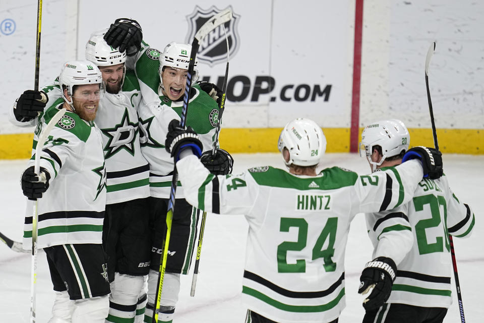 Dallas Stars left wing Jamie Benn (14), second from left, celebrates with teammates after scoring a goal during the third period of an NHL hockey game against the Minnesota Wild, Thursday, Dec. 29, 2022, in St. Paul, Minn. (AP Photo/Abbie Parr)