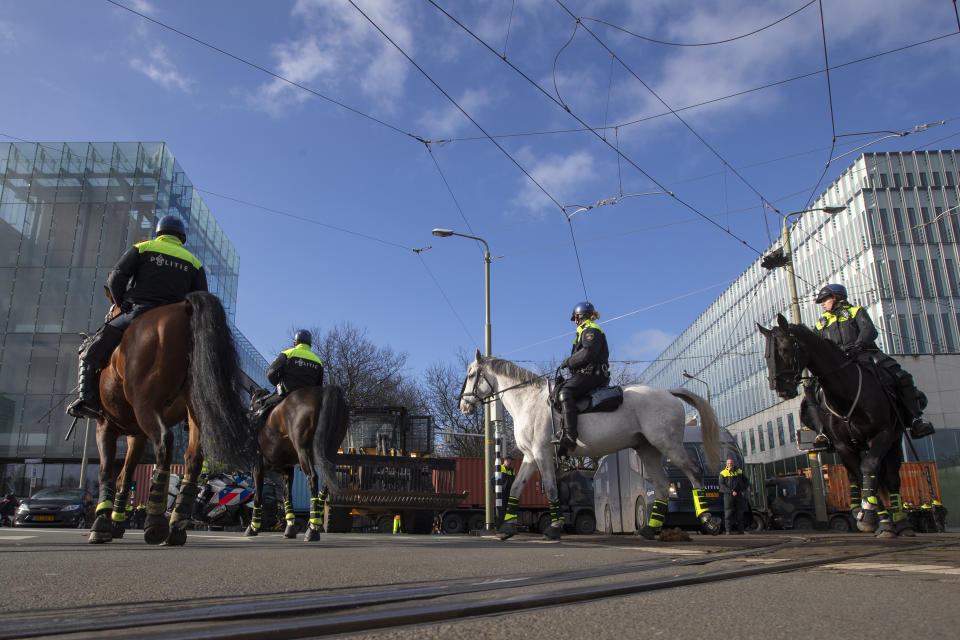 Police, front, and army trucks, rear, block the roads leading to parliament during a farmers demonstration in The Hague, Netherlands, Wednesday, Feb. 19, 2020. Dutch farmers, some driving tractors, poured into The Hague on Wednesday to protest government moves to rein in carbon and nitrogen emissions to better fight climate change. (AP Photo/Peter Dejong)