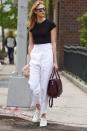 <p>Le top ne se trimballe pas toujours en robe Gucci : pantalon large et taille haute blanc, top noir et Converses. Parfait. Crédit : Getty </p>