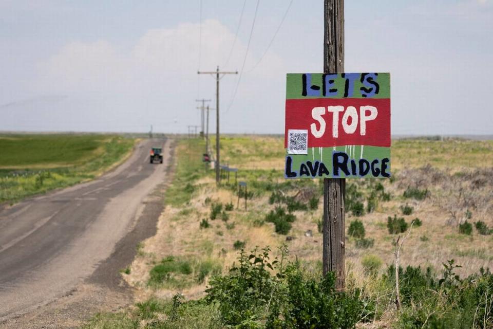 A tractor travels down Hunt Road in front of a “Let’s Stop Lava Ridge” sign near the historic site. Lindsey Wasson/AP