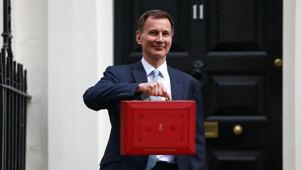 UK finance minister Jeremy Hunt poses with the red budget box outside his office on Downing Street in London on March 6, 2024. - Hannah McKay/Reuters