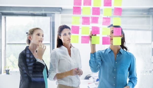 Businesswomen at the office writing down thoughts.