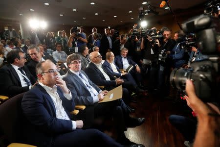 Catalan President Carles Puigdemont sits next to Catalan Government Presidency Councillor Jordi Turull as they attend the Catalan European Democratic Party (PDeCAT) extraordinary national council meeting in Barcelona, Spain October 18, 2017. REUTERS/Gonzalo Fuentes