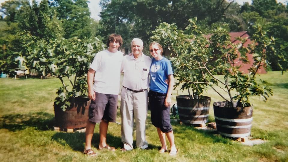Jeremy Maggio poses for a photo with his sister, nonno (grandpa) and the fig trees. His nonno grew these fig trees in the midwest after emigrating from Italy, inspiring the logo for Maggio's store.