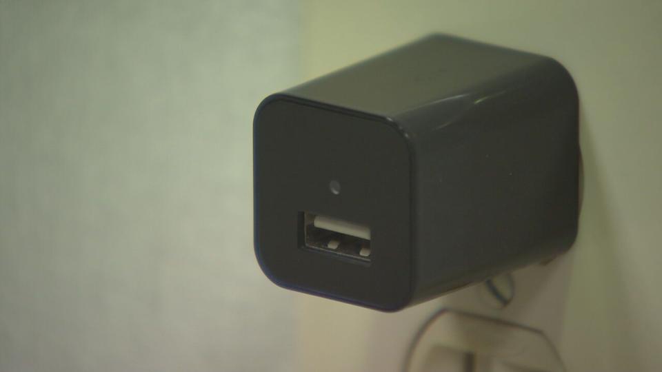 A USB charger plugged into the wall contains a hidden camera right above the port.