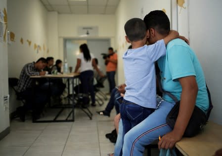 A man and his son from El Salvador wait for a turn to apply for U.S. asylum at the premises of the state migrant assistance office in Ciudad Juarez