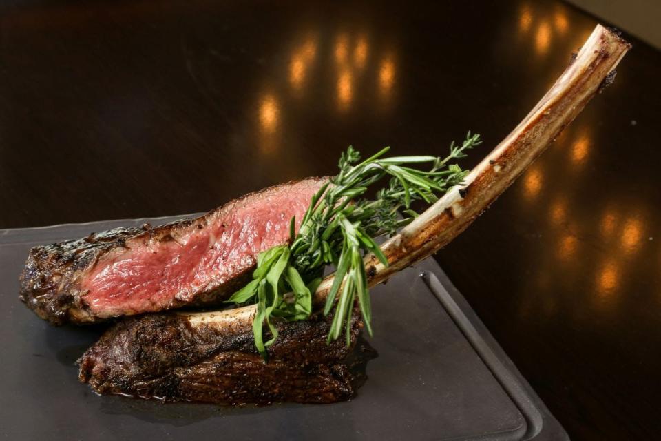 A tomahawk steak is served at Meat Market steakhouse, which has a new location in Boca Raton.