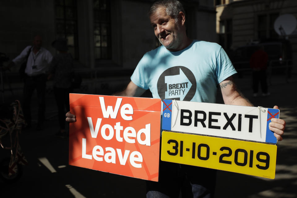 A Brexit supporter holds up a placard and a mock car number plate outside the Supreme Court in London, Thursday, Sept. 19, 2019. The Supreme Court is set to decide whether Prime Minister Boris Johnson broke the law when he suspended Parliament on Sept. 9, sending lawmakers home until Oct. 14 — just over two weeks before the U.K. is due to leave the European Union. (AP Photo/Matt Dunham)