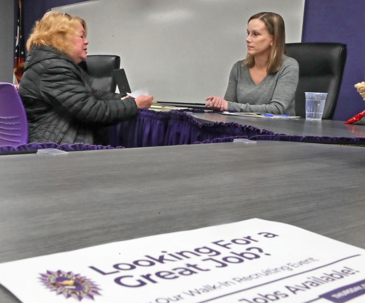 Linda Staled, left, a retired school counselor, talks with Kristi Avant of Barberton City Schools at the district's walk-in job fair for positions ranging from bus driver to substitute teachers.