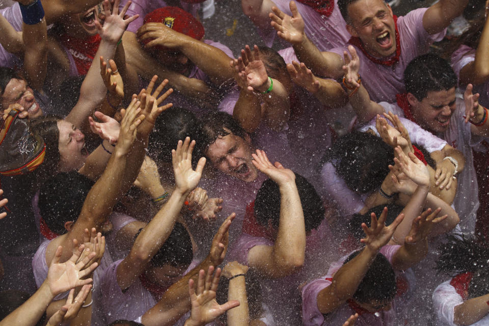 Revelers are sprayed with water after the 'Chupinazo', the official opening of the 2012 San Fermin fiestas, Friday, July 6, 2012 in Pamplona, Spain. Can we expect on Syrian Brig. Gen. Manaf Tlass had abandoned Assad's regime(AP Photo/Daniel Ochoa de Olza)