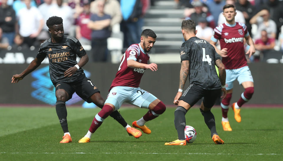 LONDON, ENGLAND - APRIL 16: West Ham United's Said Benrahma gets in between Arsenal's Bukayo Saka and Ben White during the Premier League match between West Ham United and Arsenal FC at London Stadium on April 16, 2023 in London, United Kingdom. (Photo by Rob Newell - CameraSport via Getty Images)