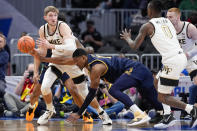 Wake Forest forward Andrew Carr, left, looks to pass to Wake Forest guard Kevin Miller as he is guarded by Notre Dame forward Kebba Njie, bottom, during the first half of the Atlantic Coast Conference second round NCAA college basketball tournament game Wednesday, March 13, 2024, in Washington. (AP Photo/Susan Walsh)