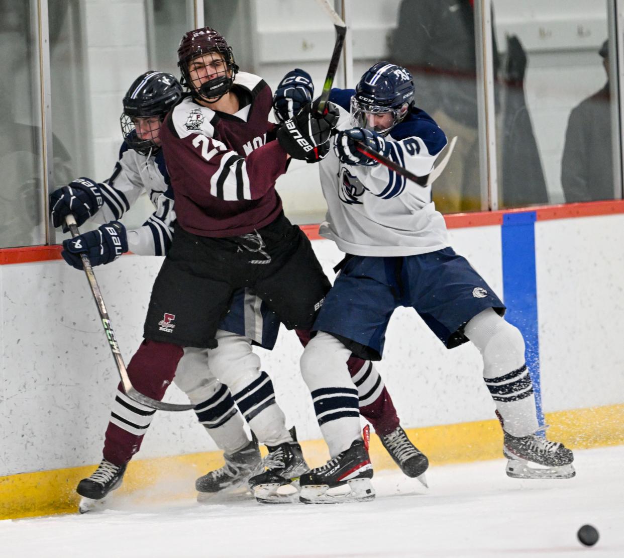 Alex Shvayko of Falmouth vs and Aidan MacKenzie and Jack Brennan of Plymouth North collide along the boards in Thursday's tournament game. Falmouth fell 2-1, ending its playoff run.