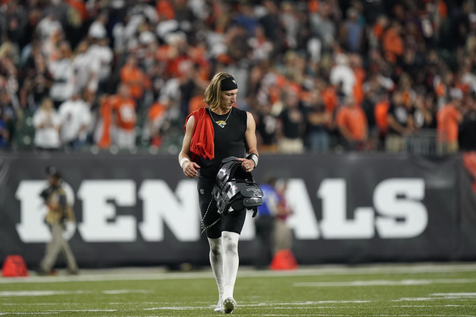 Jacksonville Jaguars quarterback Trevor Lawrence walks off the field following an NFL football game against the Cincinnati Bengals, Thursday, Sept. 30, 2021, in Cincinnati. Cincinnati won 24-21. (AP Photo/Bryan Woolston)