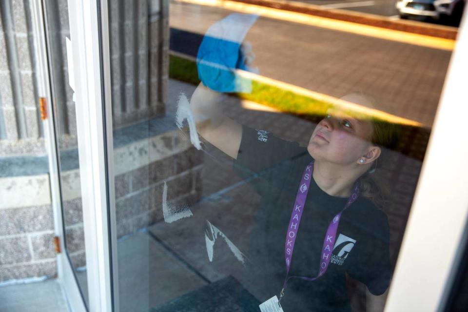 Mackensie Walker, 17, cleans windows in preparation for an upcoming event on Tuesday, Nov. 14, 2023, at the Gateway Convention Center in Collinsville, Ill. Walker is a senior at Collinsville High School and a part of an apprenticeship program for students with disabilities. Tristen Rouse/Tristen Rouse