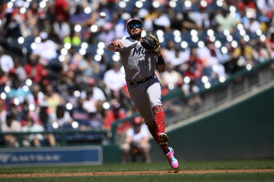 Miami Marlins shortstop Miguel Rojas throws to first to put out Washington Nationals' Lane Thomas during the third inning of a baseball game, Monday, July 4, 2022, in Washington. (AP Photo/Nick Wass)