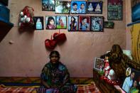 Draupadi, a former leprosy sufferer, poses with pictures of her family in a leprosy colony in New Delhi