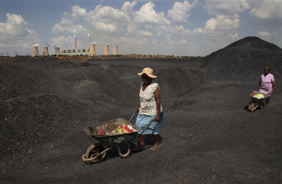 Women push wheelbarrows atop the coal-powered Duvha power station east of Johannesburg, South Africa