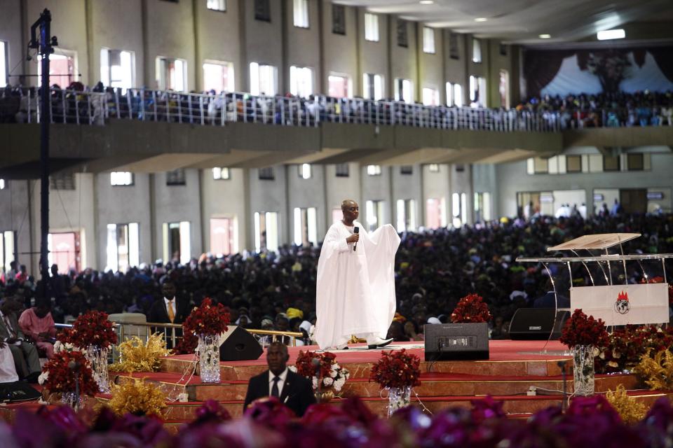 Bishop David Oyedepo (C), founder of the Living Faith Church, also known as the Winners' Chapel, conducts a service for worshippers in the auditorium of the church in Ota district, Ogun state, some 60 km (37 miles) outside Nigeria's commercial capital Lagos September 28, 2014. Hundreds of millions of dollars change hands each year in Nigeria's popular Pentecostal "megachurches", which are modelled on their counterparts in the United States. Some of these churches can hold more than 200,000 worshippers and, with their attendant business empires, they constitute a significant section of the economy, employing tens of thousands of people and raking in tourist dollars, as well as exporting Christianity globally. To match Insight NIGERIA-MEGACHURCHES/ Picture taken September 28, 2014. REUTERS/Akintunde Akinleye (NIGERIA - Tags: RELIGION BUSINESS)