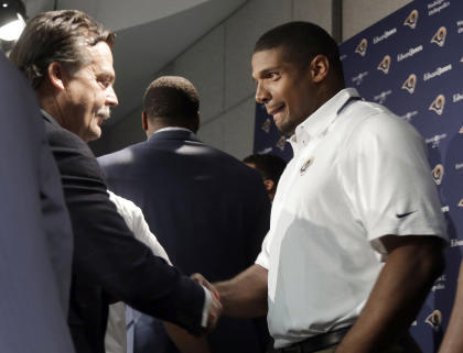 Michael Sam shakes hands with coach Jeff Fisher during a news conference in May. (AP)