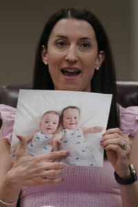 In-vitro fertilization patient Julie Cohen holds up a photo of her children 