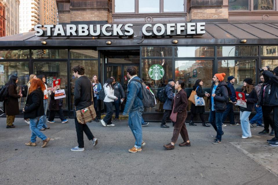 PHOTO: People picket outside of a Starbucks store as Starbucks Workers United have announced that they are waging the company's largest strike on Red Cup Day, New York City, Nov. 16, 2023. (Spencer Platt/Getty Images)