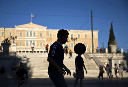 FILE PHOTO: A street performer plays with a ball at the Constitution (Syntagma) square near the Parliament building in Athens, Greece July 18, 2015. REUTERS/Ronen Zvulun /File Photo