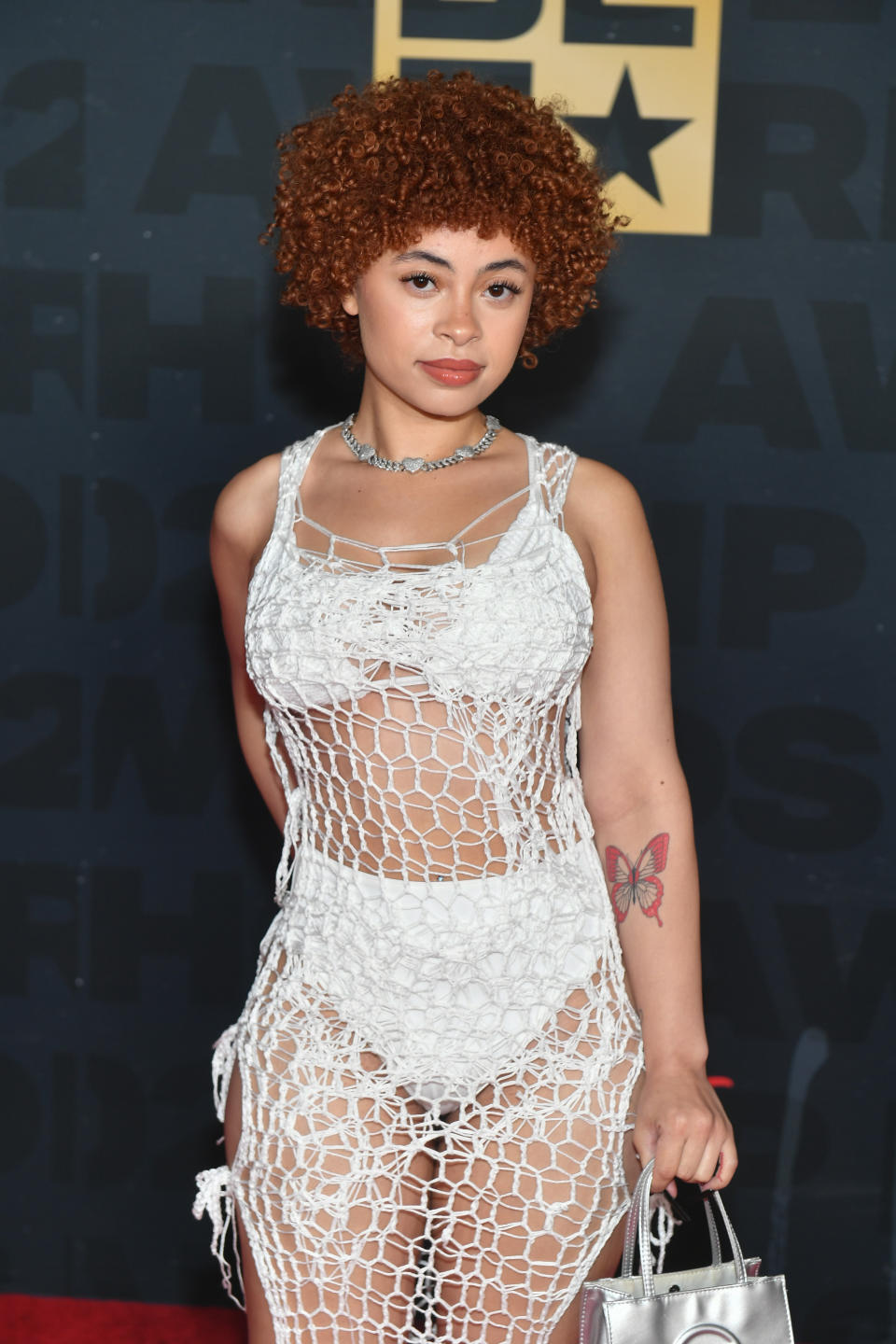 Ice Spice in a white fish net and bikini outfit