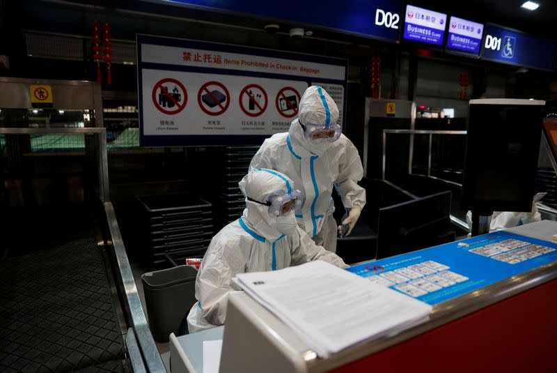 FILE PHOTO: Airline staff wear personal protective equipment to protect against COVID-19, in Beijing