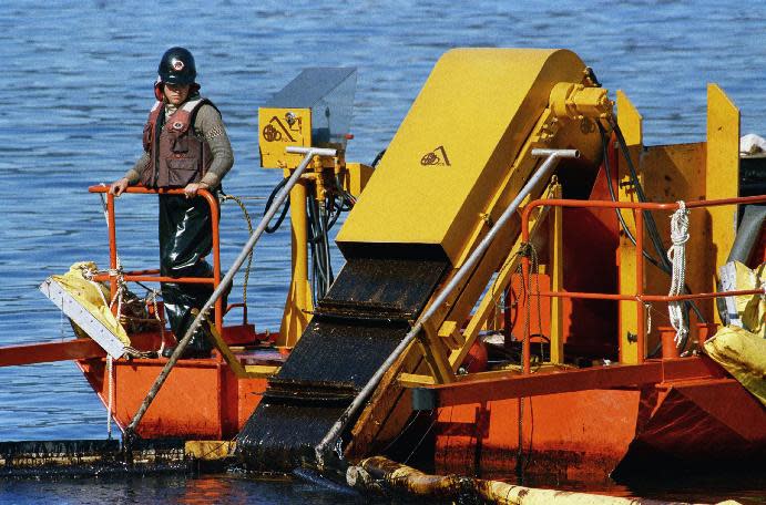 FILE - In this April 21, 1989, file photo, a skimmer is used for shoreline oil in Naked Island, Alaska. It collects the oil from off the water surface. The conveyor belt moves the oil onto a barge for storage. Nearly 25 years after the Exxon Valdez oil spill off the coast of Alaska, some damage heals, some effects linger in Prince William Sound. (AP Photo/Rob Stapleton, File)