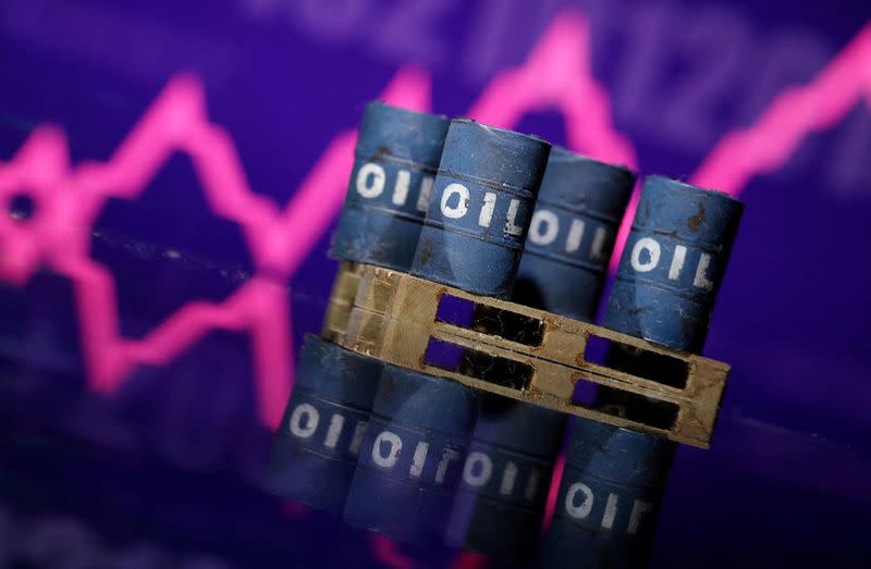 FILE PHOTO: Illustration shows miniatures of oil barrels and rising stock graph