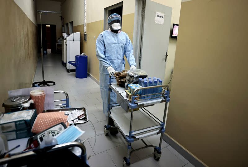 Abdoulaye Ndour, a member of the medical staff pushes the cart as he is about to distribute dinner to patients suffering from the coronavirus disease (COVID-19) at the infectious diseases department of the the University Hospital Fann, in Dakar