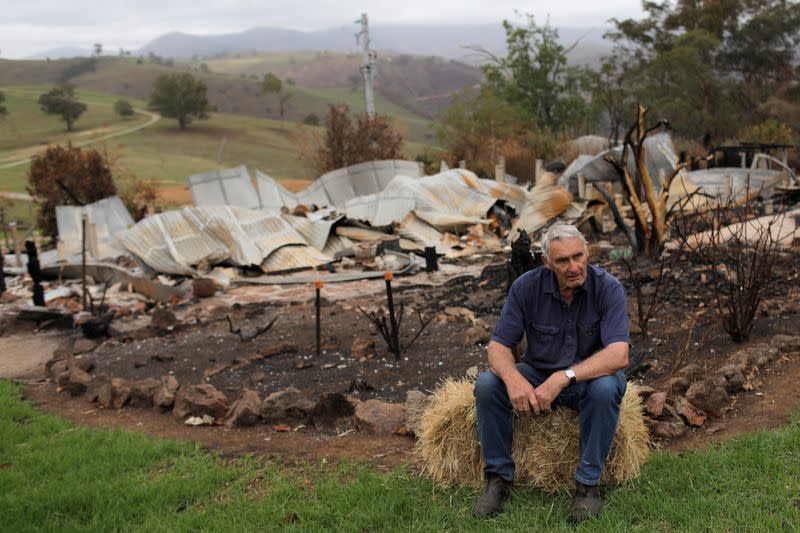 Farmer Jeff McCole, 70, sits to be interviewed in front of his family home destroyed by bushfire in Buchan, Victoria, Australia