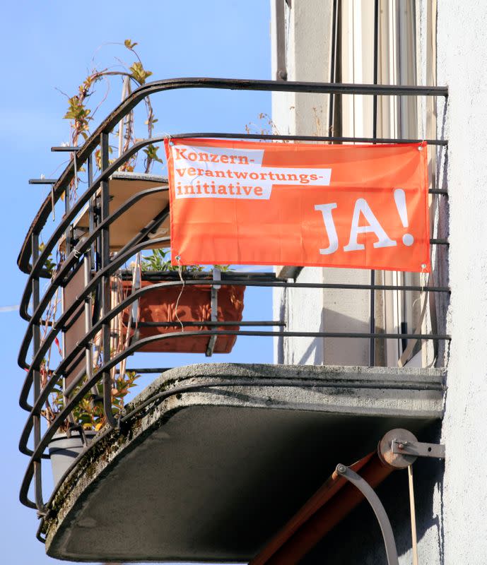 A banner reading: "Responsible Business Initiative - Yes on November 29" is seen on a balcony of a residential building in Zurich