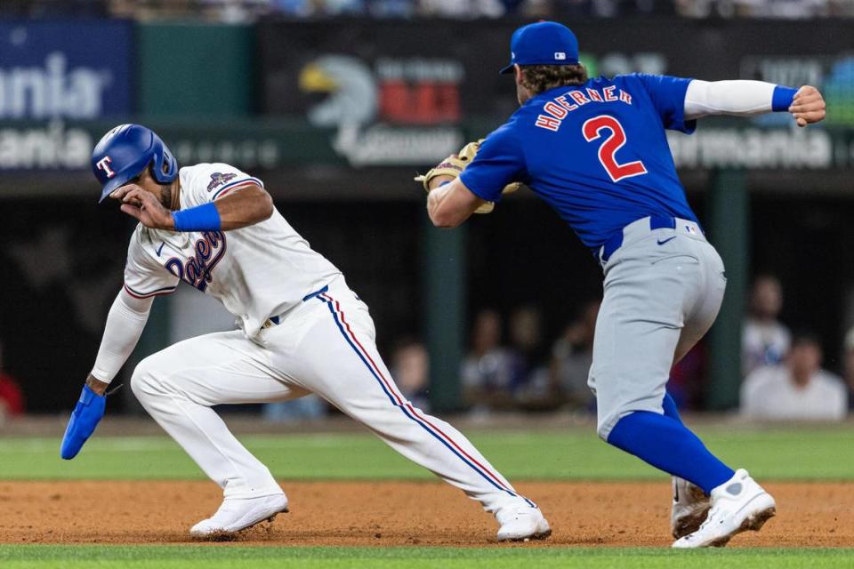 Texas Rangers first baseman Ezequiel Duran (20) attempts to avoid the tag from Chicago Cubs shortstop Nico Hoerner (2) in the fifth inning in their season opener at Globe Life Field in Arlington on Thursday, March 28, 2024. Chris Torres/ctorres@star-telegram.com