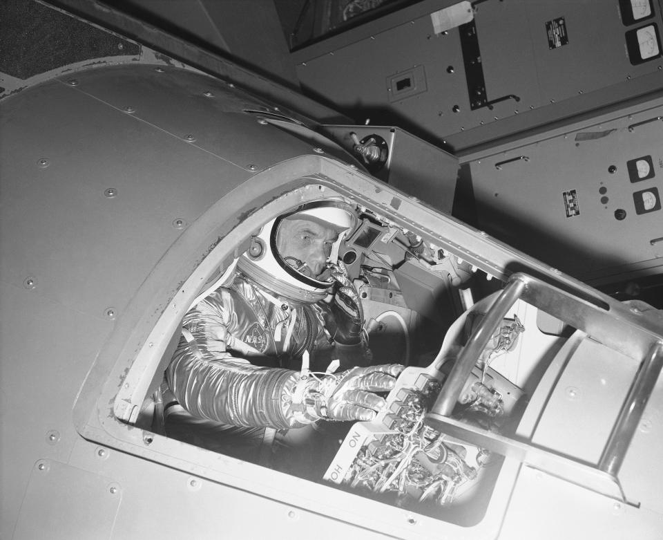 FILE - In this Jan. 11, 1961 file photo, Marine Lt. Col. John Glenn, in a space flight suit, reaches for some of the controls inside a Mercury capsule procedures trainer as he shows how the first U.S. astronaut will ride through space during a demonstration at the National Aeronautics and Space Administration Research Center in Langley Field, Va. A panel is scheduled to vote Thursday, Feb. 25, 2021, on bringing a statue of the late astronaut and U.S. senator to the Ohio Statehouse to mark major future milestones, such as his birthday and the anniversary of his famous space flight. Glenn died in 2016 at age 95. (AP Photo)