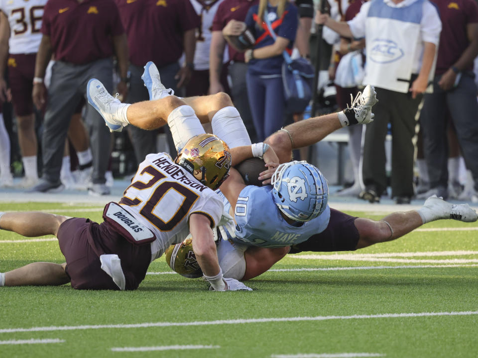 North Carolina quarterback Drake Maye (10) is brought down by Minnesota linebacker Maverick Baranowski (6) and defensive back Jack Henderson (20) during the second half of an NCAA college football game, Saturday, Sept. 16, 2023, in Chapel Hill, N.C. (AP Photo/Reinhold Matay)