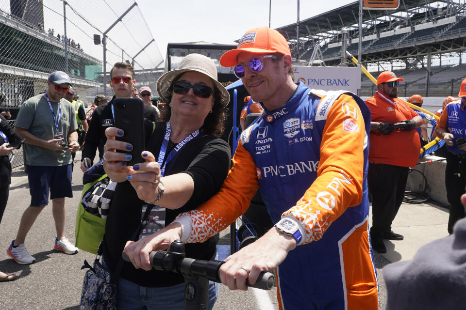 Scott Dixon, of New Zealand, poses with a fan following practice for the Indianapolis 500 auto race at Indianapolis Motor Speedway, Monday, May 23, 2022, in Indianapolis. (AP Photo/Darron Cummings)