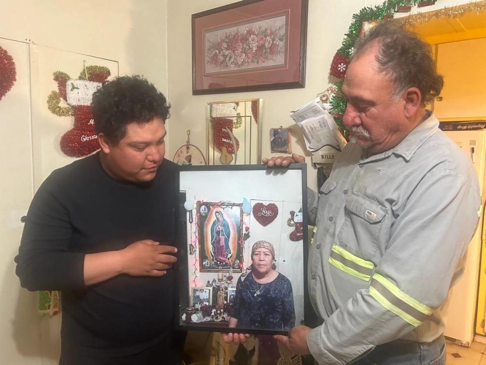 Eduardo Martínez, de 57 años, y su hijo César Martínez, de 24, sostienen una foto de su esposa y madre Margarita Martínez, recientemente fallecida de cáncer de mama, el martes 28 de noviembre.