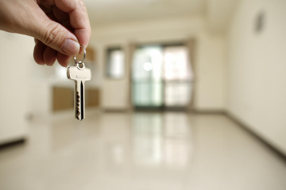 Apartment key in man hand in closeup view as house rental concept