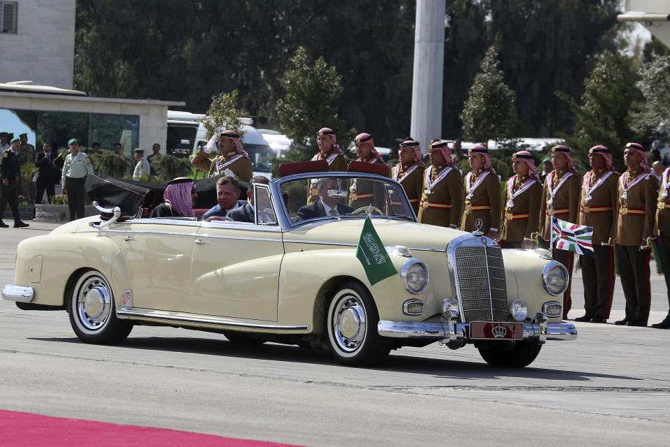 Saudi Arabia's King Salman, left, rides in a vintage Mercedes with Jordan's King Abdullah II in a lavish welcome ceremony complete with cannon salutes and guards on camel back, Amman Jordan, Monday, March 27, 2017. Salman is in Jordan to attend the annual Arab Summit, to be held on Wednesday. Issues on the summit agenda include conflicts in Syria, Libya and Yemen. Saudi Arabia is an important financial backer of Jordan. (AP Photo/ Raad Adayleh)