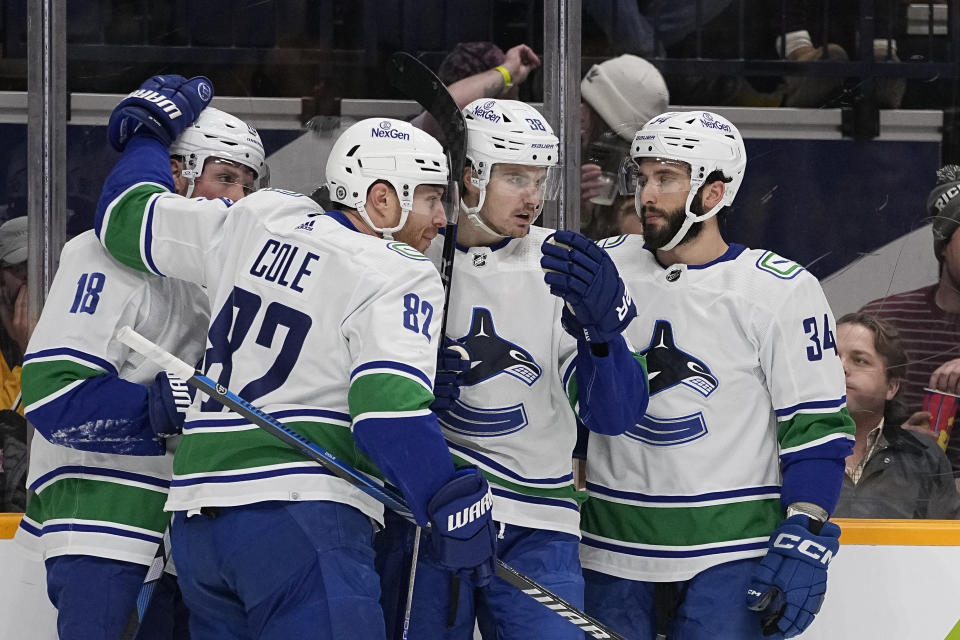 Vancouver Canucks center Nils Aman, second from right, celebrates a goal with teammates Sam Lafferty (18), Ian Cole (82) and Phillip Di Giuseppe (34) during the first period of an NHL hockey game against the Nashville Predators, Tuesday, Dec. 19, 2023, in Nashville, Tenn. (AP Photo/George Walker IV)