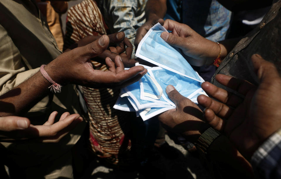 Protective masks are distributed outside a railway station in Mumbai.