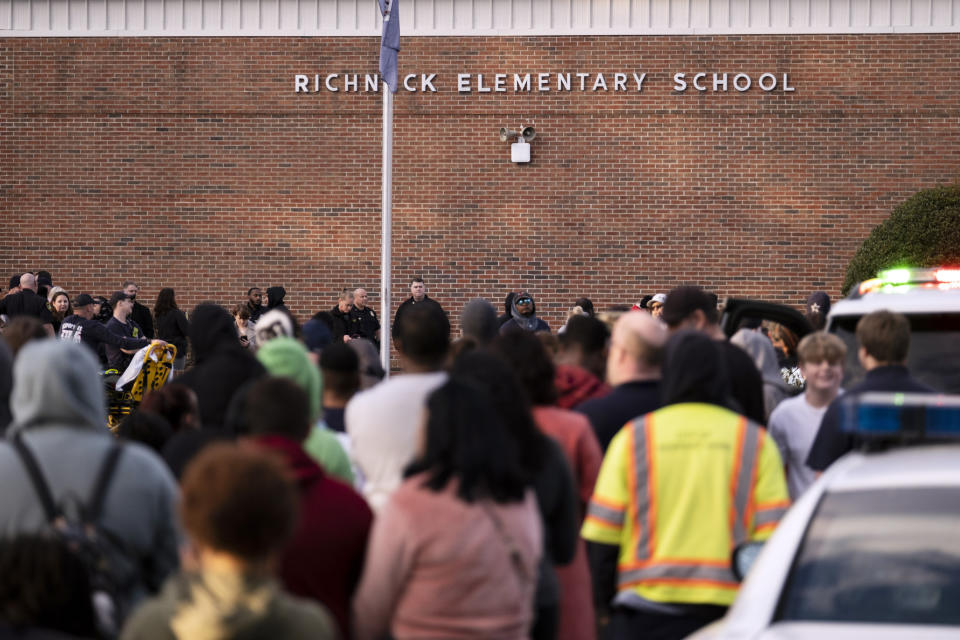 FILE - Students and police gather outside of Richneck Elementary School after a shooting, Jan. 6, 2023 in Newport News, Va. A Virginia teacher who was shot and seriously wounded by her 6-year-old student filed a lawsuit Monday, April 3, 2023, seeking $40 million in damages from school officials, accusing them of gross negligence and of ignoring multiple warnings the day of the shooting that the boy was armed and in a “violent mood.”(Billy Schuerman/The Virginian-Pilot via AP, File)
