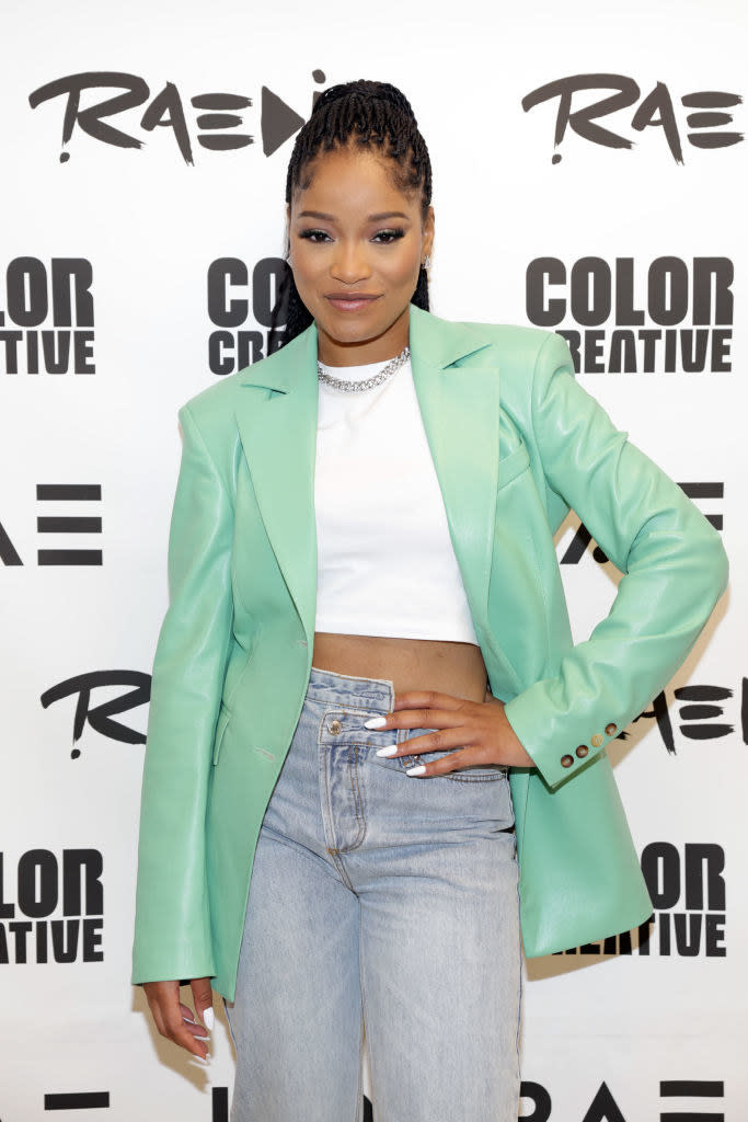 Keke Palmer smiling with her hand on her hip