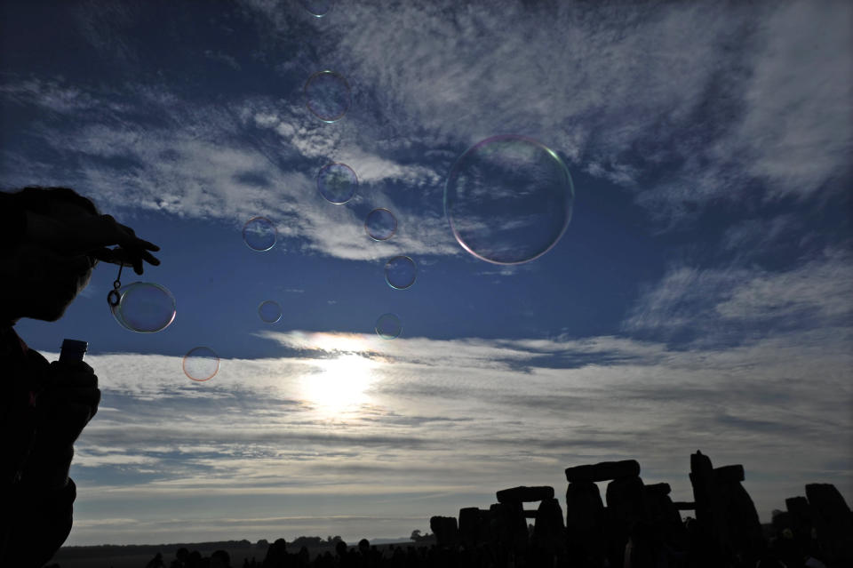 A reveler blows bubbles as the sun rises behind Stonehenge during the pagan festival of 'Summer Solstice' at Stonehenge in Wiltshire in southern England, on June 21, 2010. (Carl Court/AFP/Getty Images)